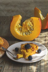 Homemade fresh round bright orange sliced pumpkin tart pie recipe with raisins on rustic wood background. Pumpkin Pie decorated for Halloween. Celebrating Thanksgiving Holiday Tradition Concept