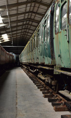 Fototapeta na wymiar Rotten Railway carriages in a warehouse in the UK.