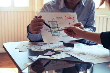 Designers planning to work together Draw application program in mobile phone and website development.