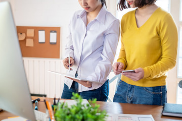 Two female designers drawing a website outline and website ux app development on mobile phone.