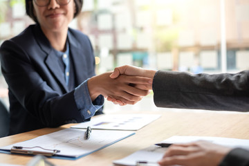 Business people shaking hands and congratulating at meeting.