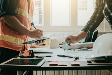 Engineer work together at meeting and planning construction projects on the desk in the office.