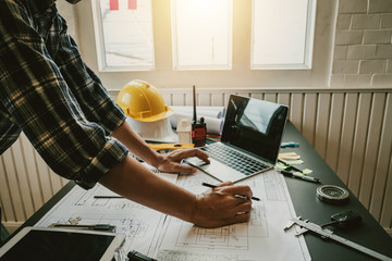 Architect with creativity for designing projects and drawing on blueprint on the office.