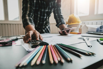 Architect with creativity for designing projects and drawing on blueprint on the office.