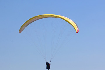 Tandem Paraglider flying yellow wing