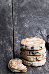 Stack of iced Welsh cakes on rustic wooden table