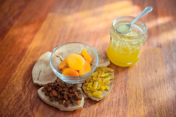 Raisins, dried apricots and honey on the table