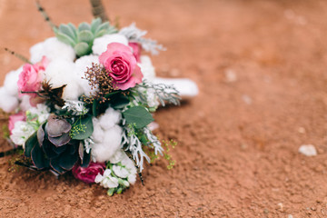 Modern flower wedding boutique with cotton, pink roses, and succulents, dessert wedding, red dirt background