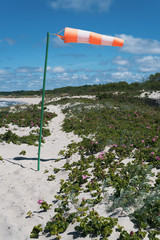 Windsock on a background of clear sky at the sea shore.