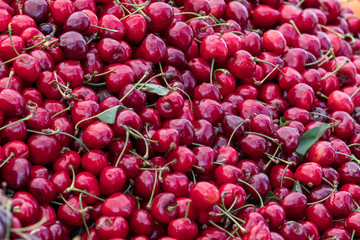 Large group fresh organic cherries available for sale at a street food market, natural red  background with soft focus