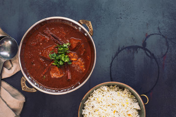 Kashmiri Lamb Rogan Josh. Slow cooked lamb curry served with pulao rice and garnished with coriander. Top view, blank space