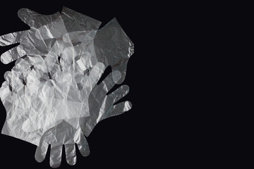 Plastic bag with handles, gloves, on a black background . Used plastic bag for recycling. Concept -...