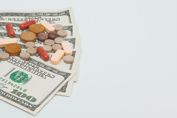 colored medicinal pills and american dollars on white a background
