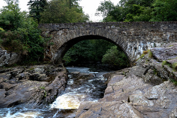 Fototapeta na wymiar Highland River and Old Stone Bridge in Scotland