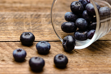 Blaubeeren in einem Glas auf einem braunen Holztisch