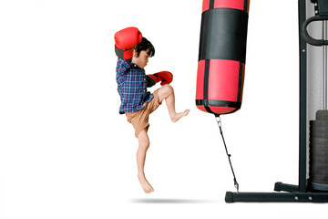 Little boy exercising with a boxing sack on studio