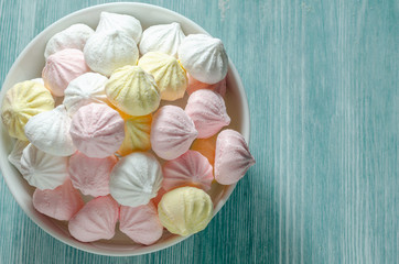 Meringues in a white bowl. Colorful delicious dessert.