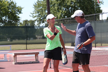 a mixed doubles pickleball team celebrates a tournament victory