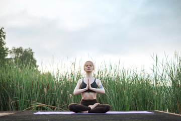 Girl practice yoga early morning on pier
