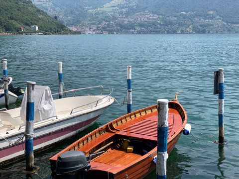 Two Boats At The Pier. Lake Surrounded By Mountains. Quiet Place For Rest.