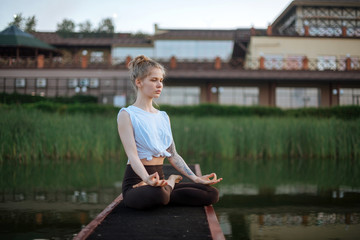 Girl practice yoga early morning on pier