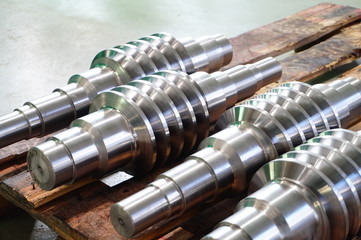 The worm shaft after processing lies on a wooden rack, the production of helically screw products.
