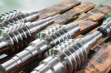 The worm shaft after processing lies on a wooden rack, the production of helically screw products.
