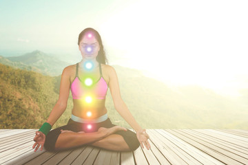 Woman meditating with colored chakra points