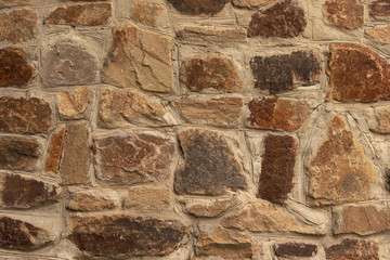 Background in the form of a stone wall made of many flat buta stones of light brown color