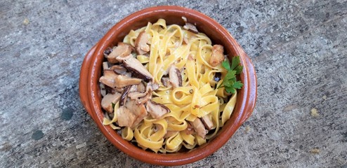 Tagliatelle with Harvested wild boletus mushrooms and bacon sauce on wooden background