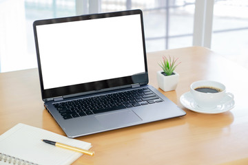 Laptop computer, white screen, coffee cup, notepad