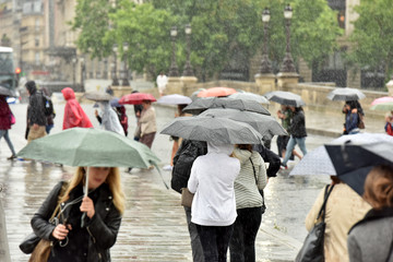 People with umbrellas. It is raining heavily.
