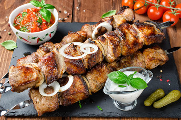 Pork skewers with onions on a wooden table