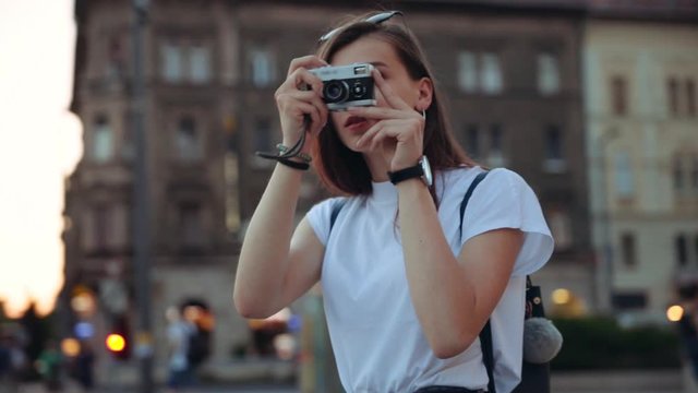 Stylish girl takes pictures on retro camera trip attractive tourist photography caucasian beautiful place happy photographing nature vacation sightseeing summer travel camera landscape slow motion