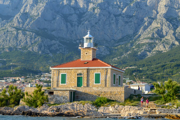 Fototapeta na wymiar Lighthouse on Makarska riviera beach in Makarska, Croatia on June 17, 2019.