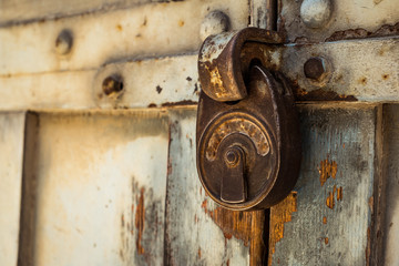 old rusty padlock on wooden door