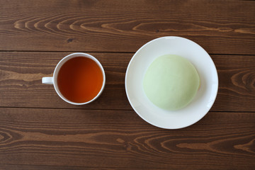 お皿にのせた メロン パン 紅茶 木のテーブル