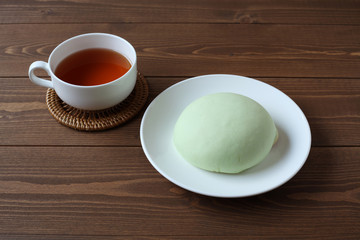 お皿にのせた メロン パン 紅茶 木のテーブル