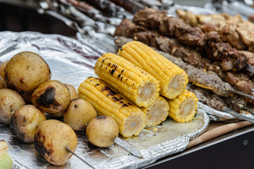 fried apples, corn and meat on skewers