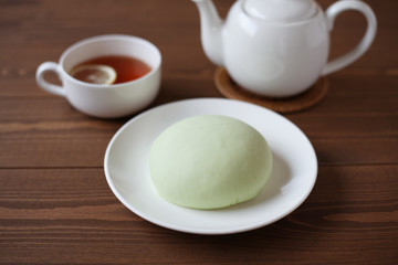 お皿にのせた メロン パン 紅茶 木のテーブル