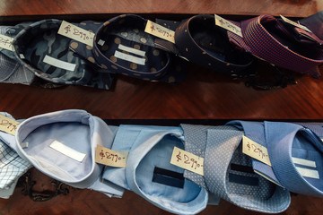 Rows of shirts with price tags accommodated on the sideboard of a store