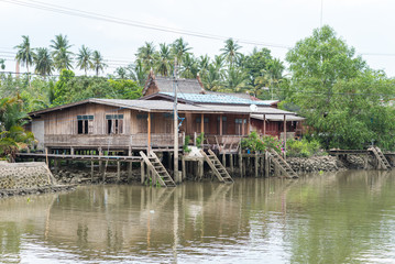 Wooden stilt house beside a canal in Samut Songkhram province, Thailand. At a boat tour from...