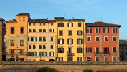 Historical apartment house facades in Pisa, Italy, at sunset