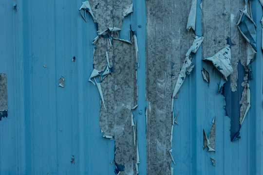 Peeling blue paint on tin wall