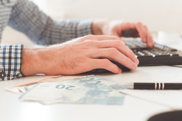 Office work. Businessman work on computer with finances. Blurred background, film effect.