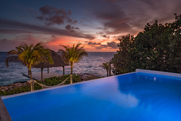 Fototapeta na wymiar Sunset over the sea from a house and swimming pool