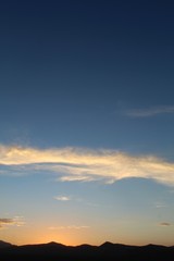 Fototapeta premium Heavens illuminate as sun sets over the Hexie Mountains of Joshua Tree National Park. Although much of the range is within the Mojave, its edges transition and integrate with the Colorado Desert.