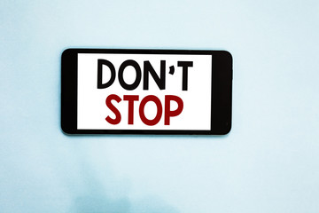 Text sign showing Don t not Stop. Conceptual photo Continue what had been doing without rendering a delay Cell phone white screen over light blue background text messages apps