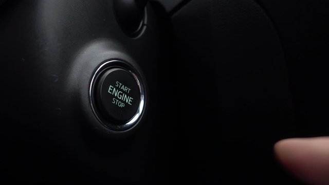Pressing the button to start the car engine.