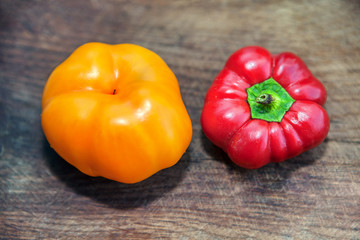 red and yellow peppers on the wooden background